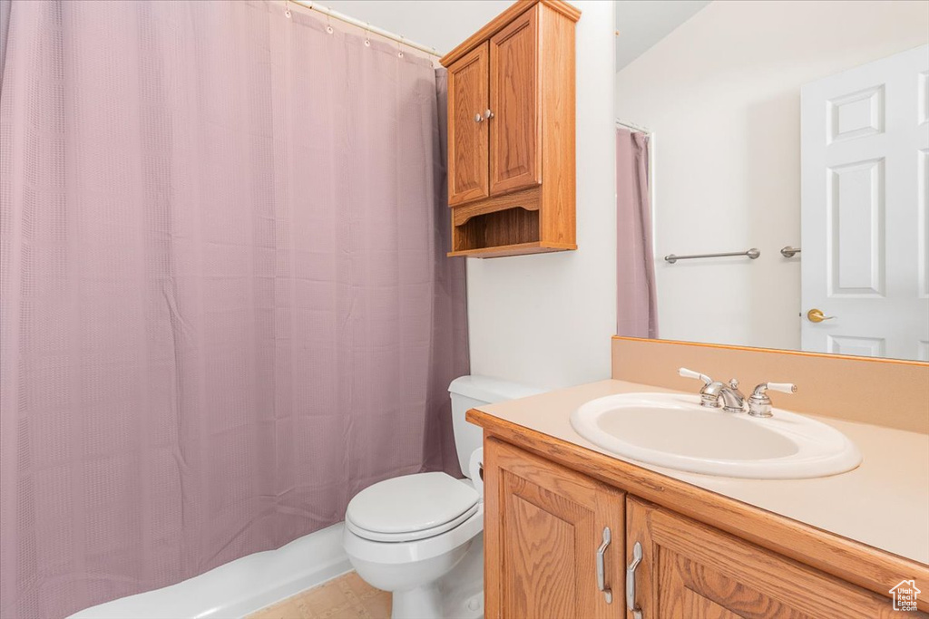 Bathroom featuring tile patterned flooring, toilet, and vanity