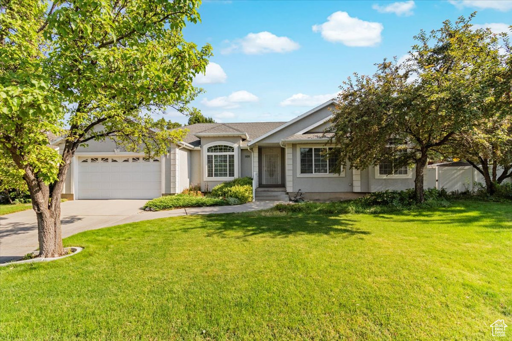 Ranch-style house with a garage and a front lawn