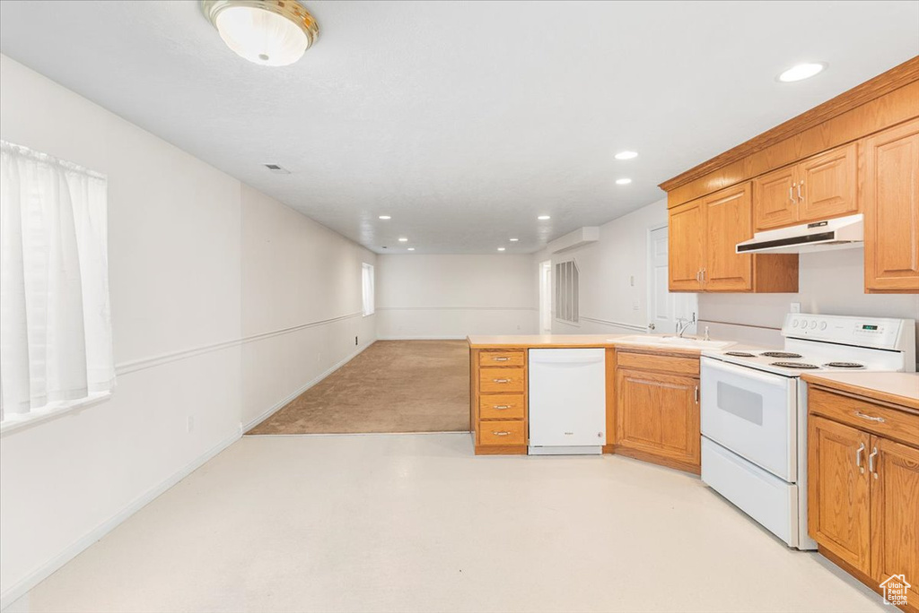 Kitchen with sink, kitchen peninsula, and white appliances