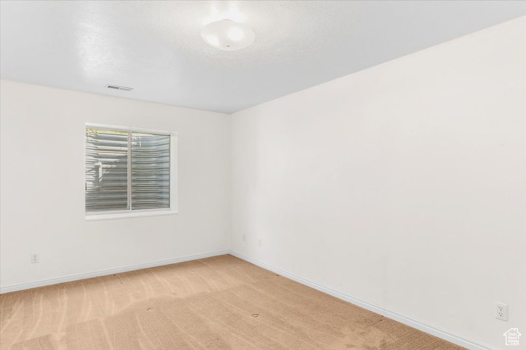 Spare room featuring light colored carpet