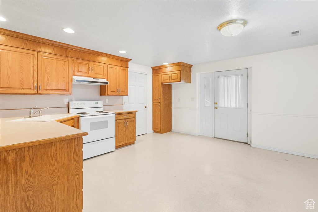 Kitchen with white range with electric cooktop and sink