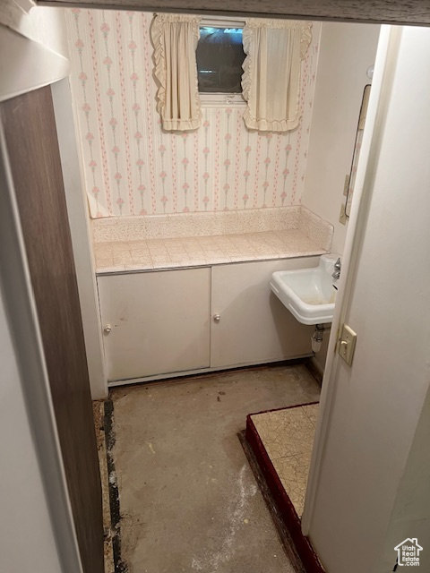 Bathroom featuring sink and concrete floors