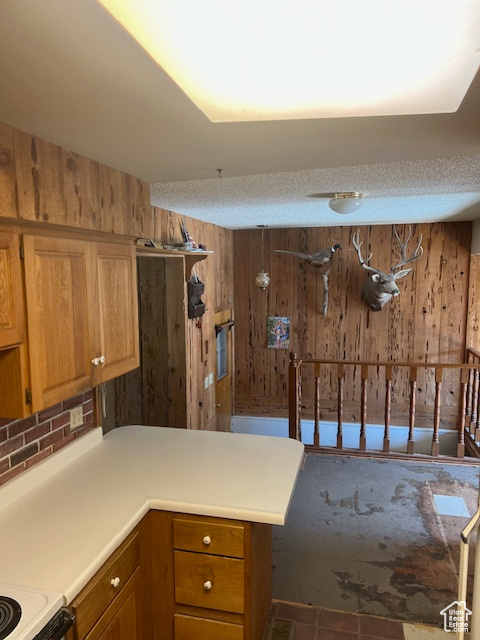 Kitchen featuring wood walls, a textured ceiling, and tile patterned flooring