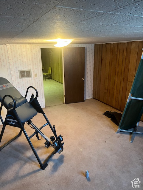 Exercise area featuring a textured ceiling and wooden walls