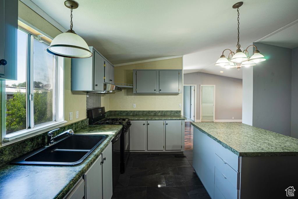 Kitchen featuring electric range, vaulted ceiling, dark tile patterned flooring, and pendant lighting