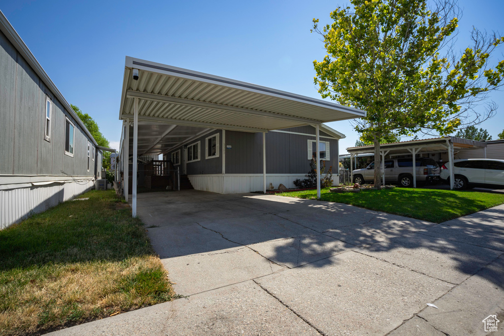 View of front facade with a front lawn and a carport