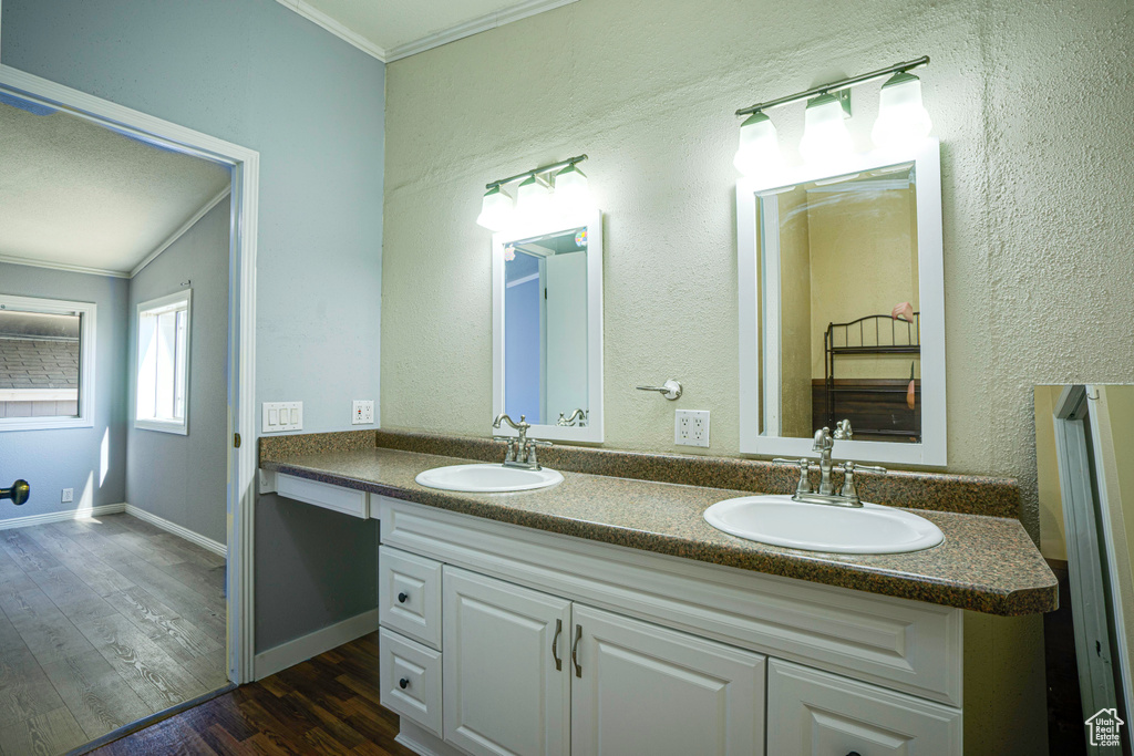 Bathroom with ornamental molding, vaulted ceiling, hardwood / wood-style flooring, and dual bowl vanity