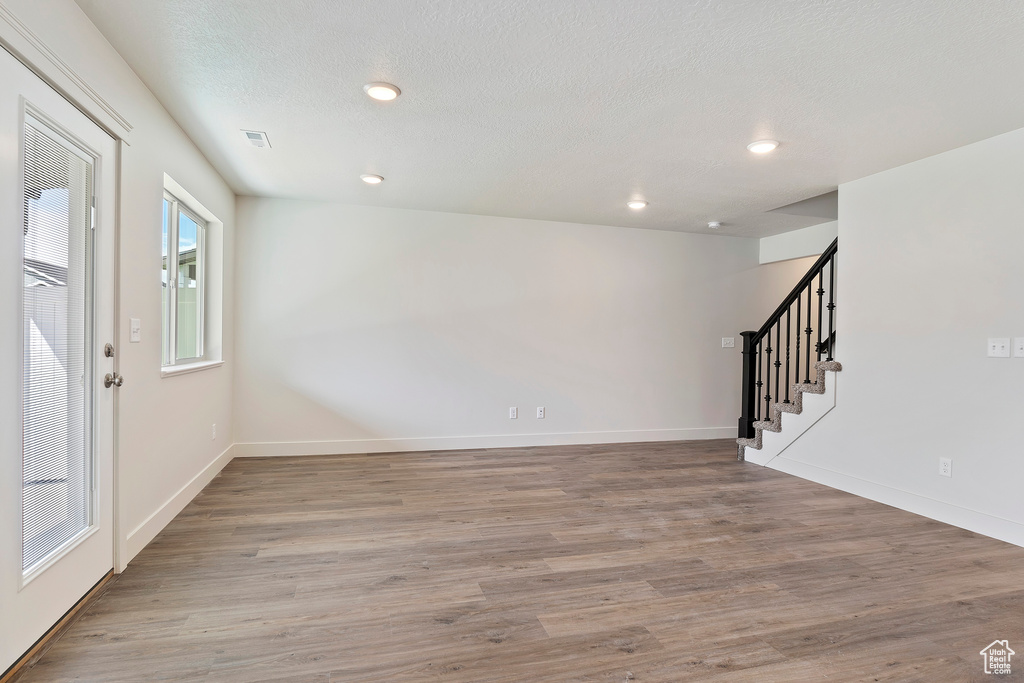 Entryway with a textured ceiling and light hardwood / wood-style floors