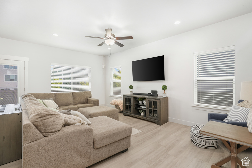 Living room with light hardwood / wood-style flooring and ceiling fan