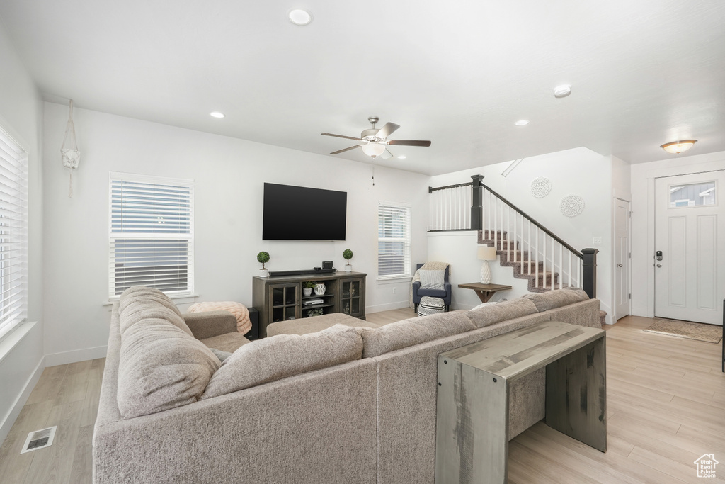 Living room featuring light hardwood / wood-style flooring, a wealth of natural light, and ceiling fan