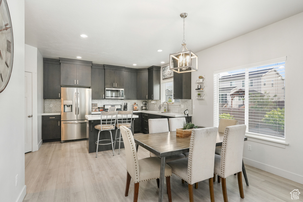 Dining area featuring light hardwood / wood-style floors, a notable chandelier, and sink