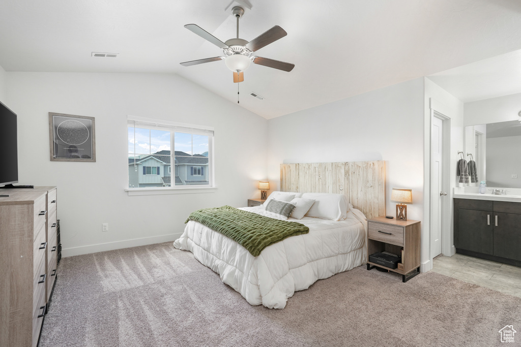 Carpeted bedroom with vaulted ceiling, ensuite bathroom, and ceiling fan