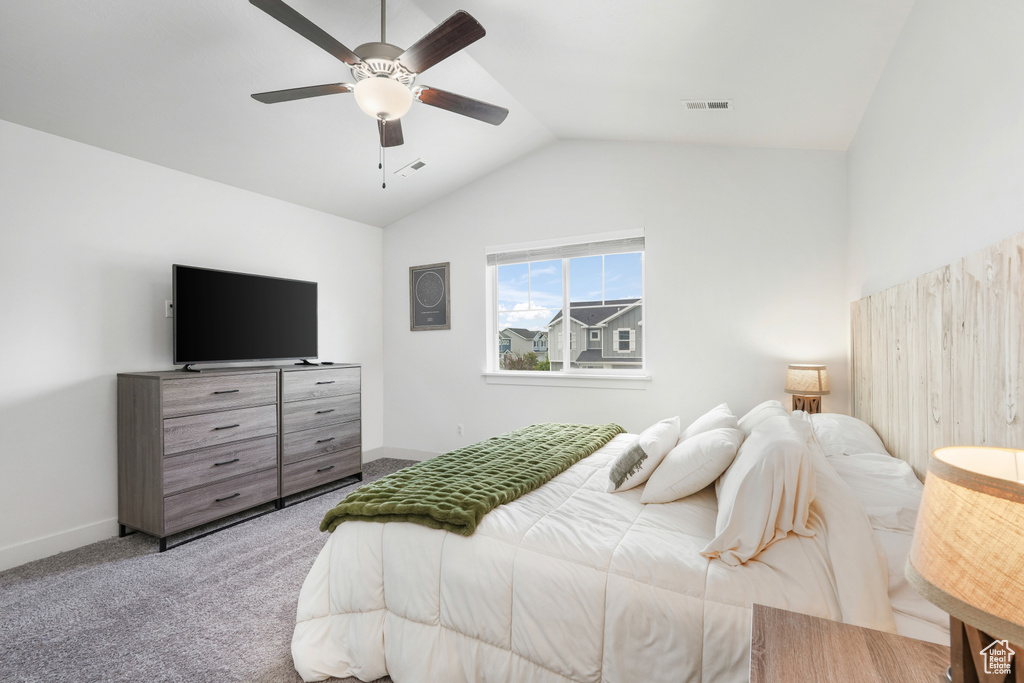 Carpeted bedroom with vaulted ceiling and ceiling fan