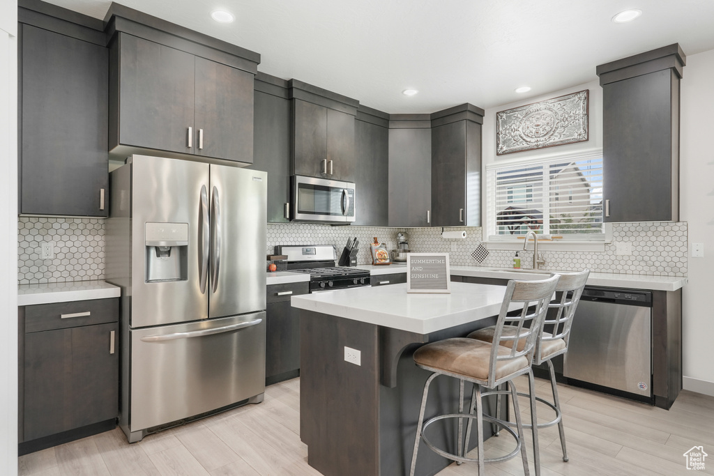 Kitchen featuring stainless steel appliances, backsplash, and a kitchen island