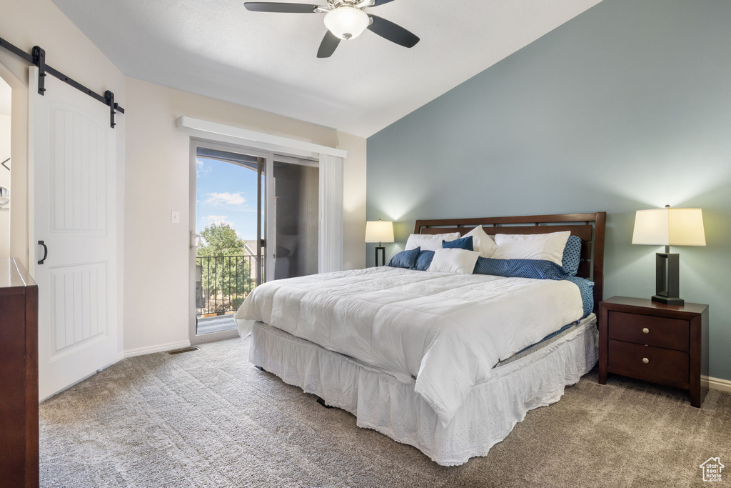 Carpeted bedroom featuring a barn door, lofted ceiling, access to outside, and ceiling fan