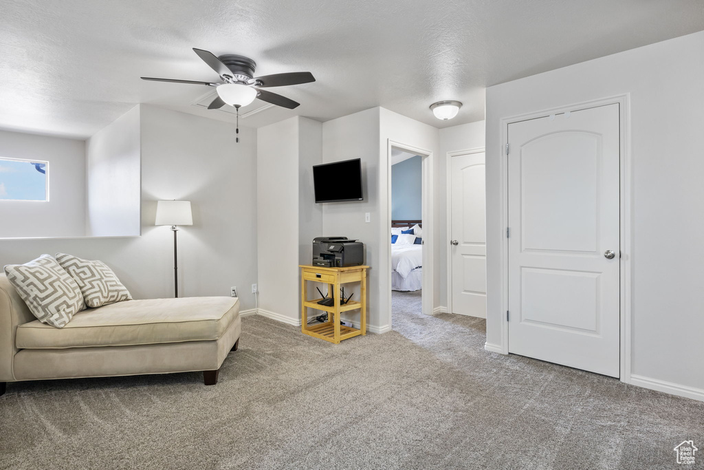 Carpeted living room with ceiling fan