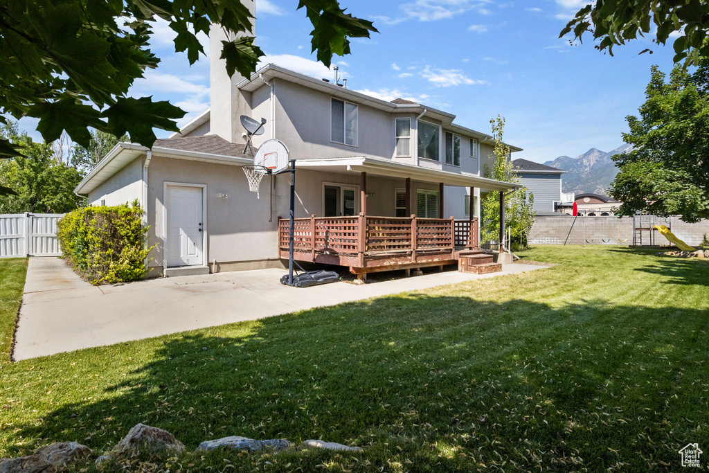 Back of house with a lawn and a playground