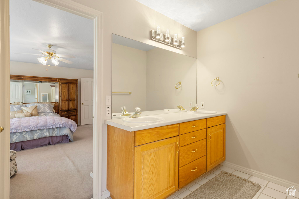 Bathroom with ceiling fan, tile patterned floors, and dual bowl vanity