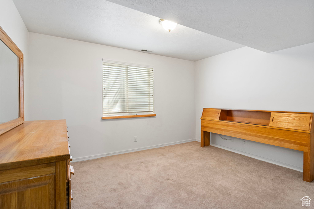 Unfurnished bedroom featuring light carpet