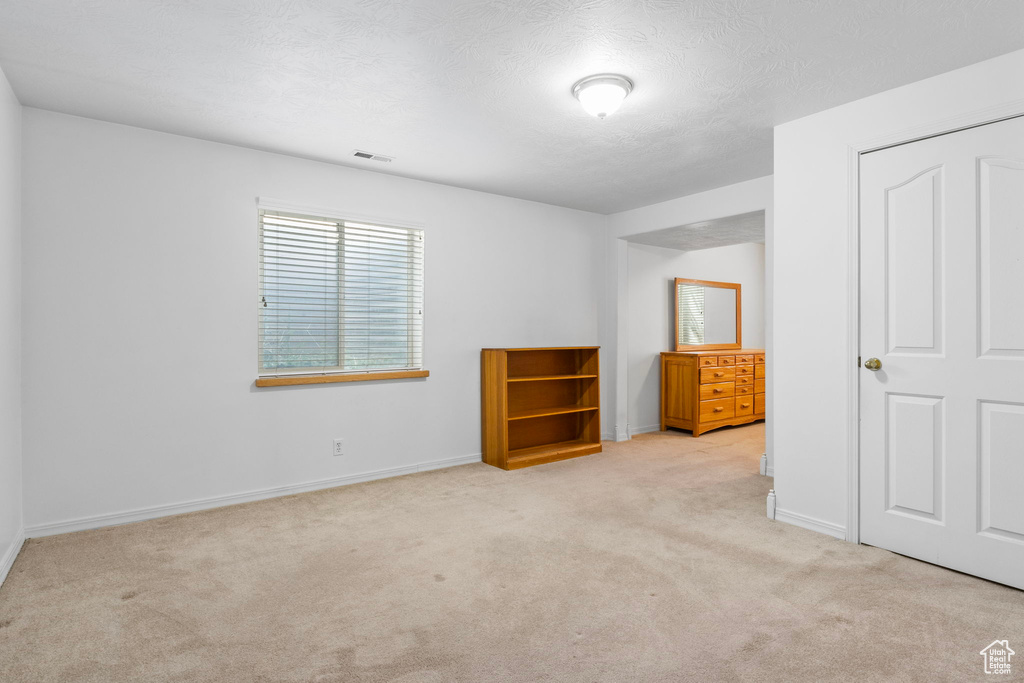 Unfurnished bedroom featuring light colored carpet