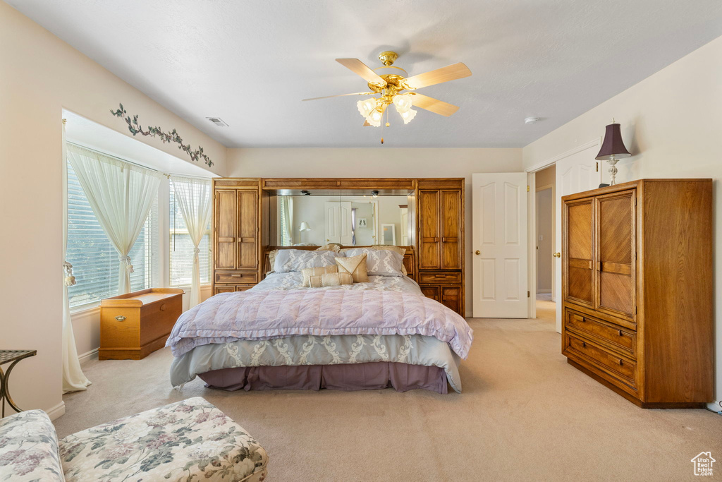 Carpeted bedroom featuring ceiling fan