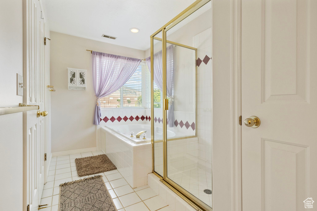 Bathroom featuring tile patterned flooring and separate shower and tub