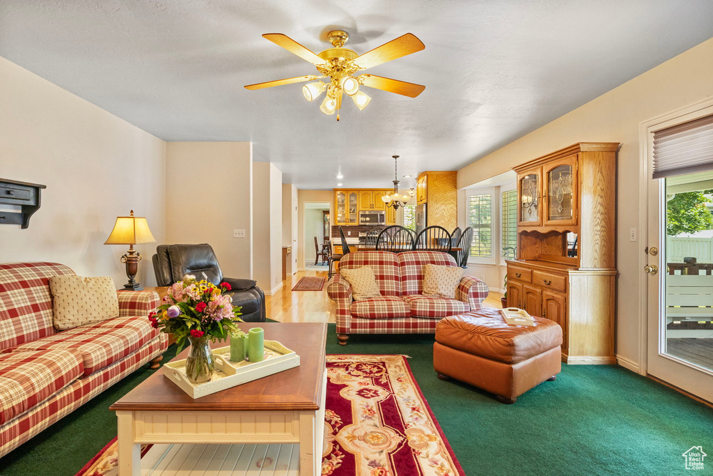 Carpeted living room featuring ceiling fan