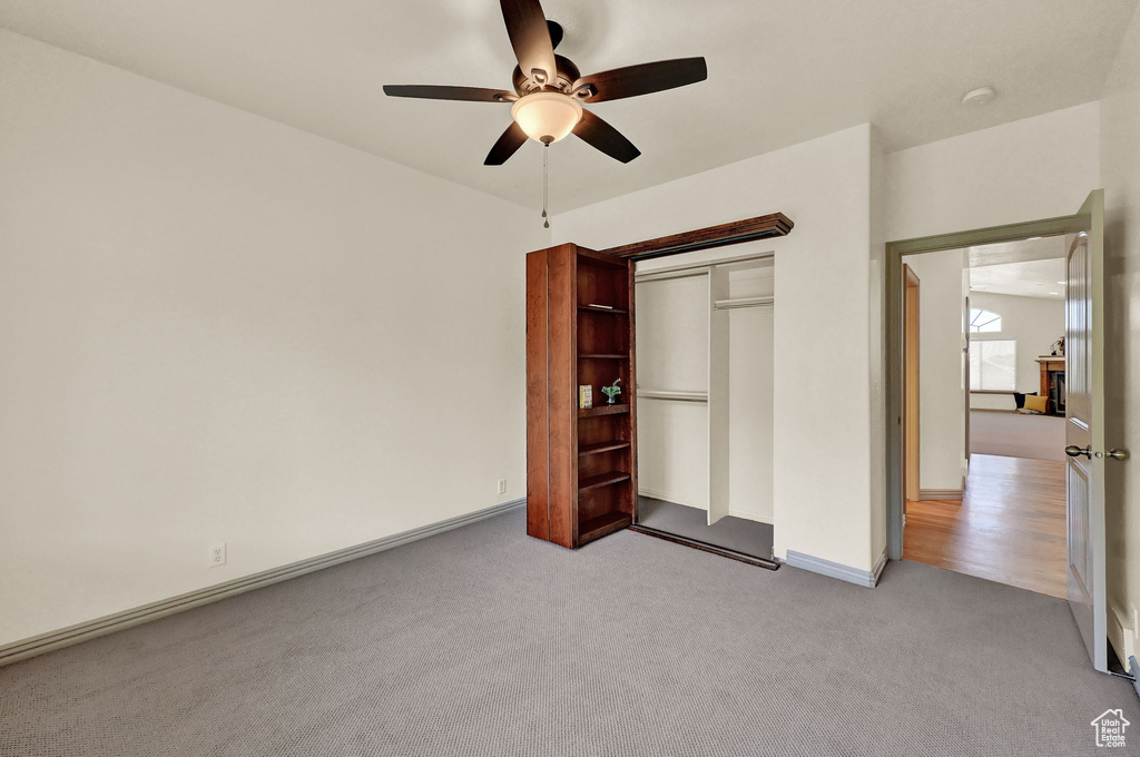 Unfurnished bedroom with light carpet, a closet, and ceiling fan