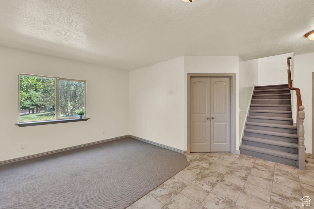 Carpeted empty room featuring a textured ceiling