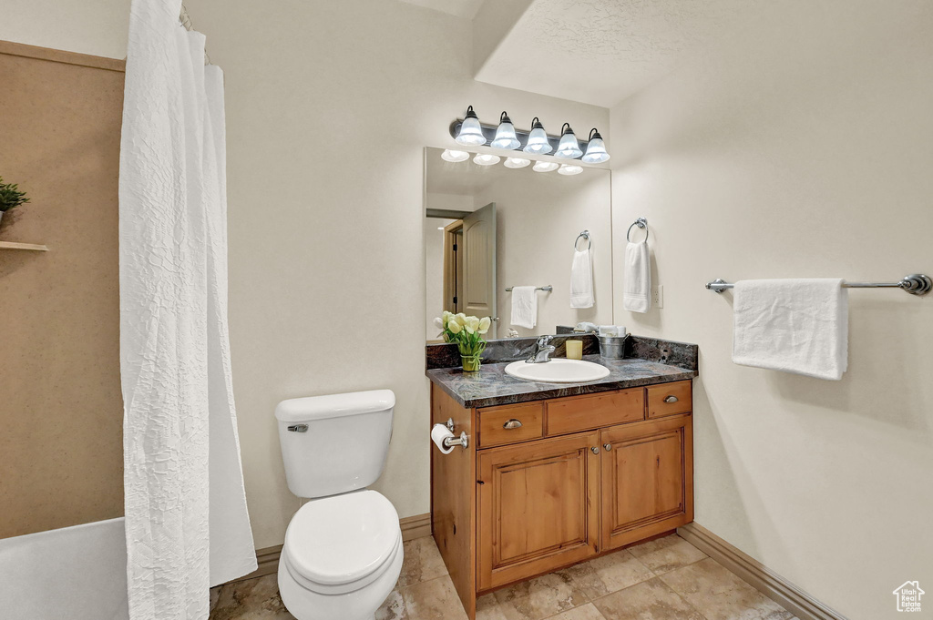 Bathroom featuring vanity, tile patterned flooring, and toilet