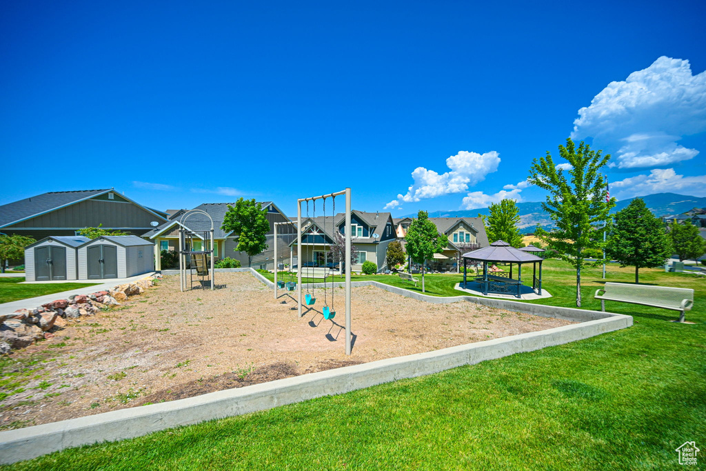 View of jungle gym with a gazebo and a lawn