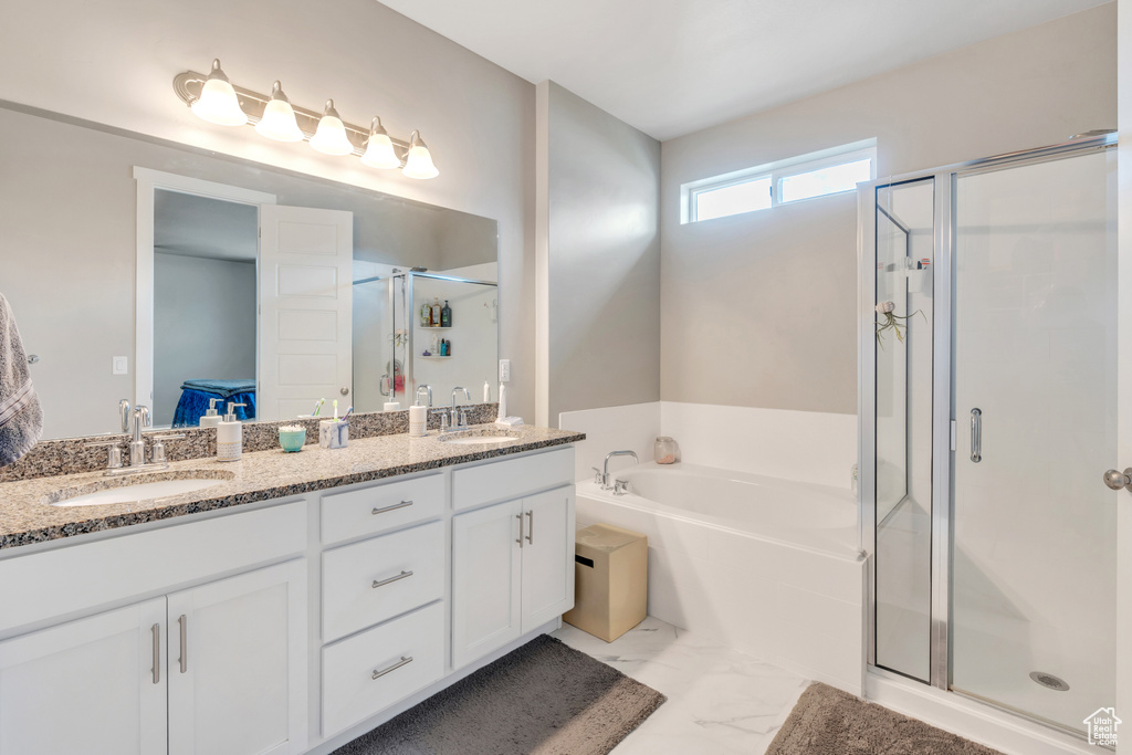 Bathroom featuring tile patterned floors, separate shower and tub, and dual bowl vanity