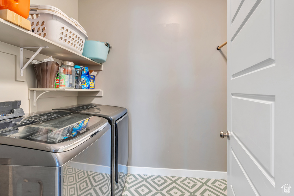 Clothes washing area with tile patterned flooring and independent washer and dryer