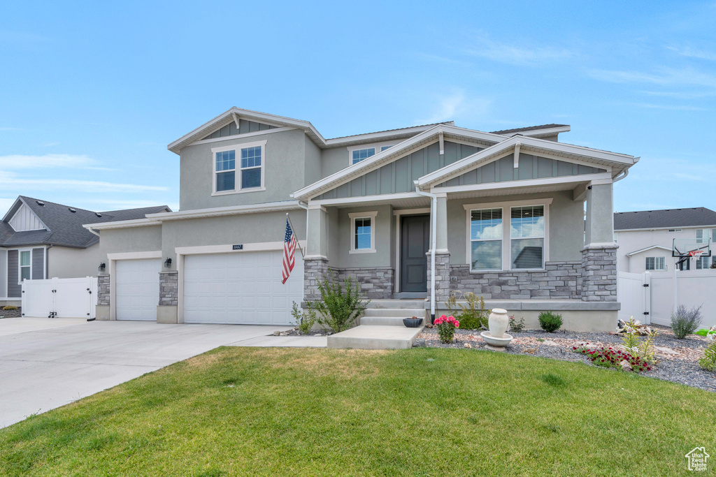 Craftsman house featuring a garage and a front yard