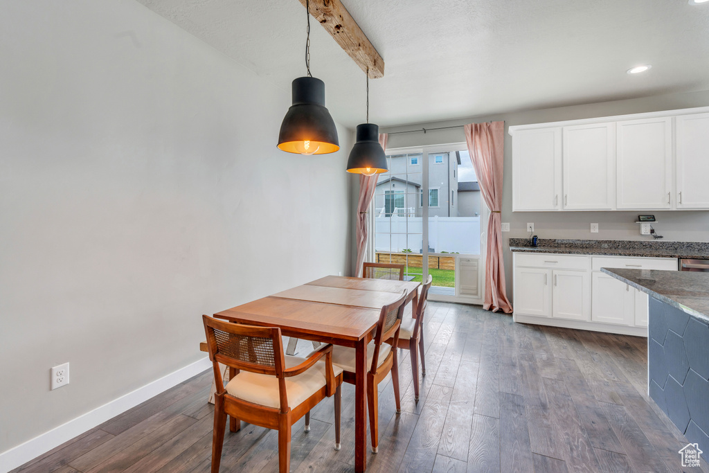 Dining area with beam ceiling and dark wood-type flooring