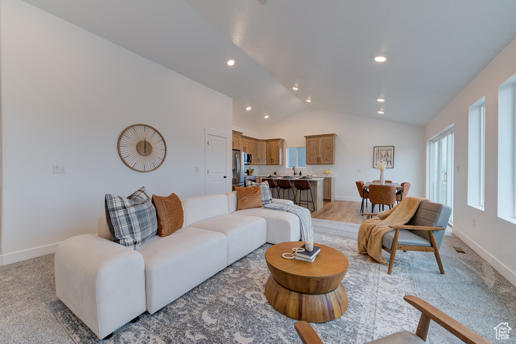 Carpeted living room with lofted ceiling