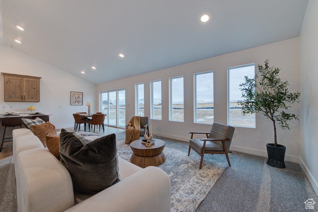 Carpeted living room featuring vaulted ceiling and a water view