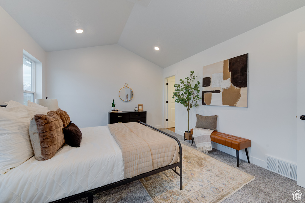 Carpeted bedroom featuring vaulted ceiling