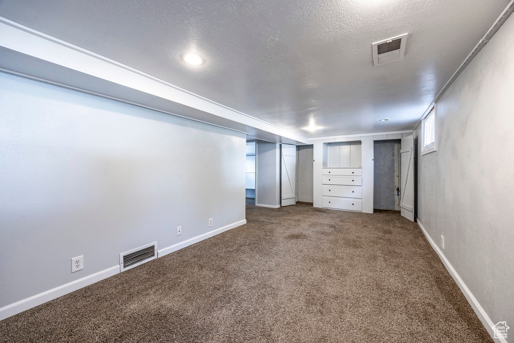 Basement featuring carpet floors and a textured ceiling