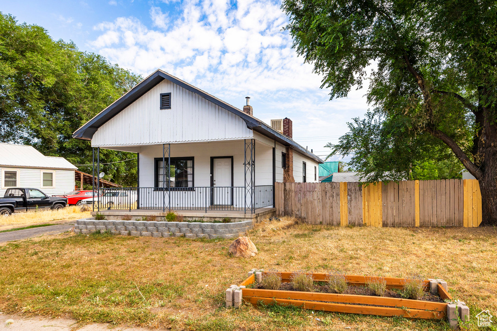 View of front of property featuring a front yard and covered porch