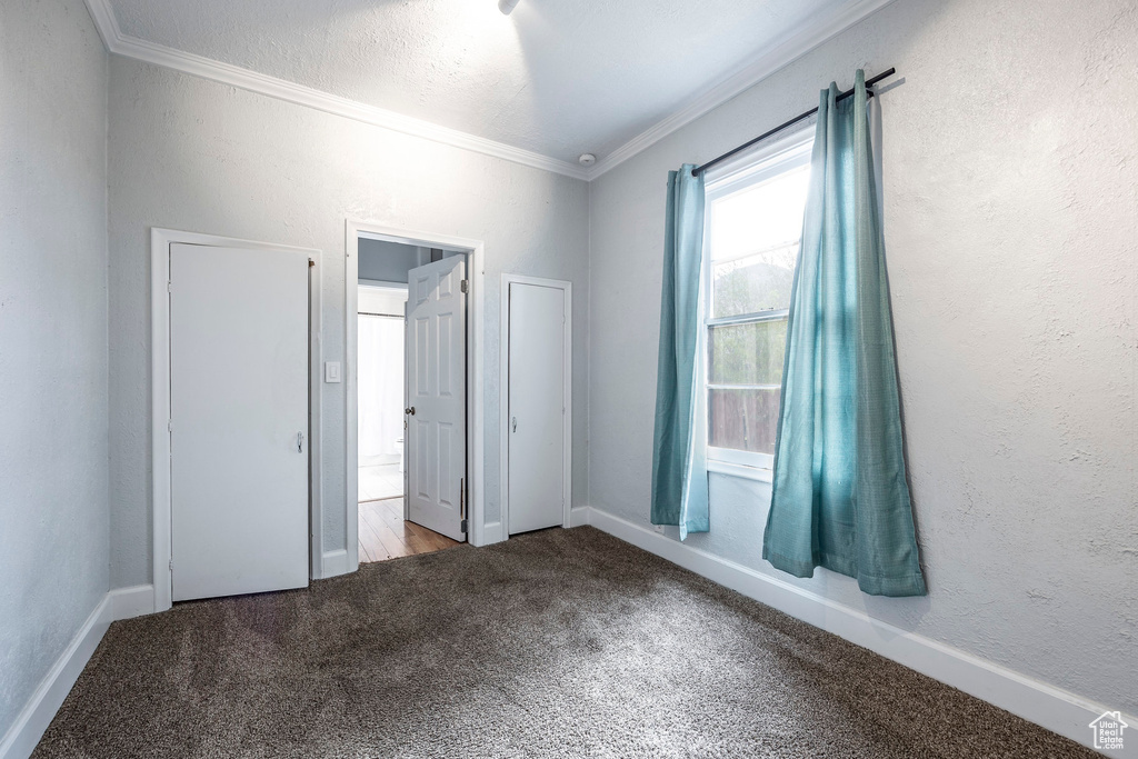 Unfurnished bedroom with carpet and ornamental molding