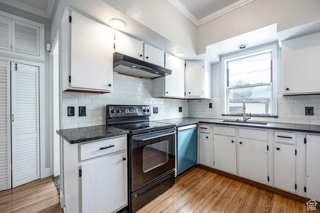 Kitchen with light wood-type flooring, white cabinets, dishwasher, black electric range oven, and sink