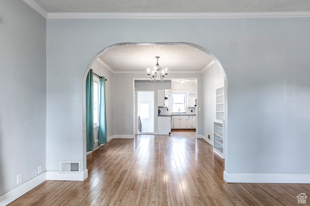 Entryway featuring light hardwood / wood-style floors, a notable chandelier, and a textured ceiling