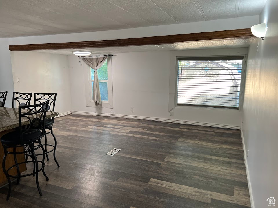 Empty room featuring dark hardwood / wood-style flooring