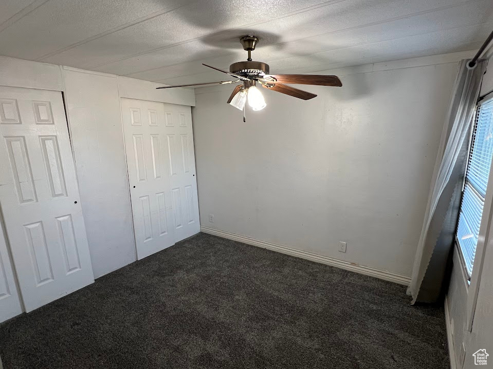 Unfurnished bedroom with ceiling fan and carpet