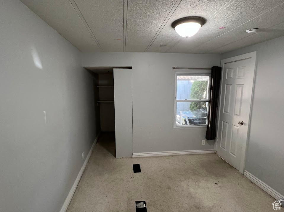 Unfurnished bedroom featuring a textured ceiling and a closet