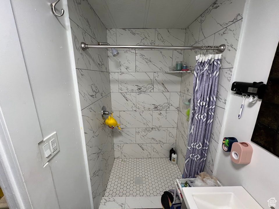 Bathroom featuring tiled shower and sink