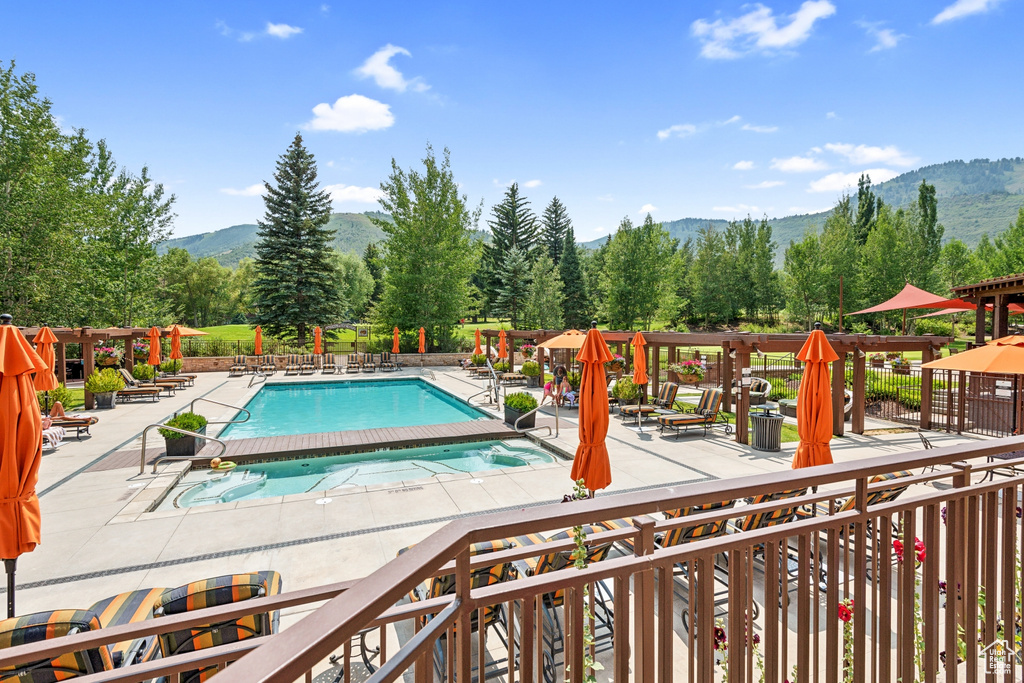 View of swimming pool with a mountain view and a patio area