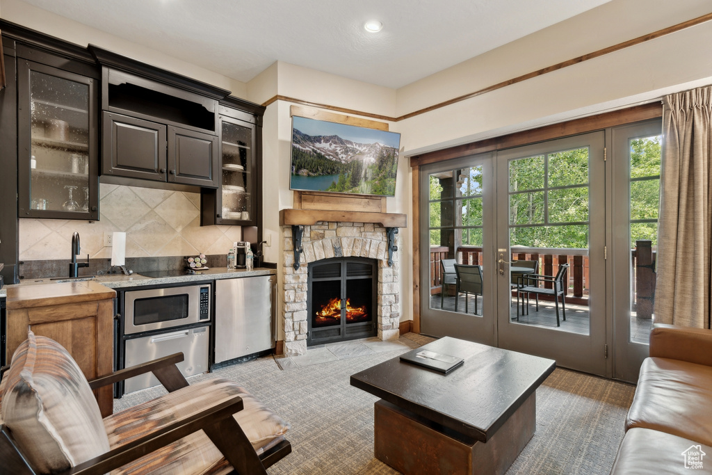 Carpeted living room featuring a fireplace and french doors