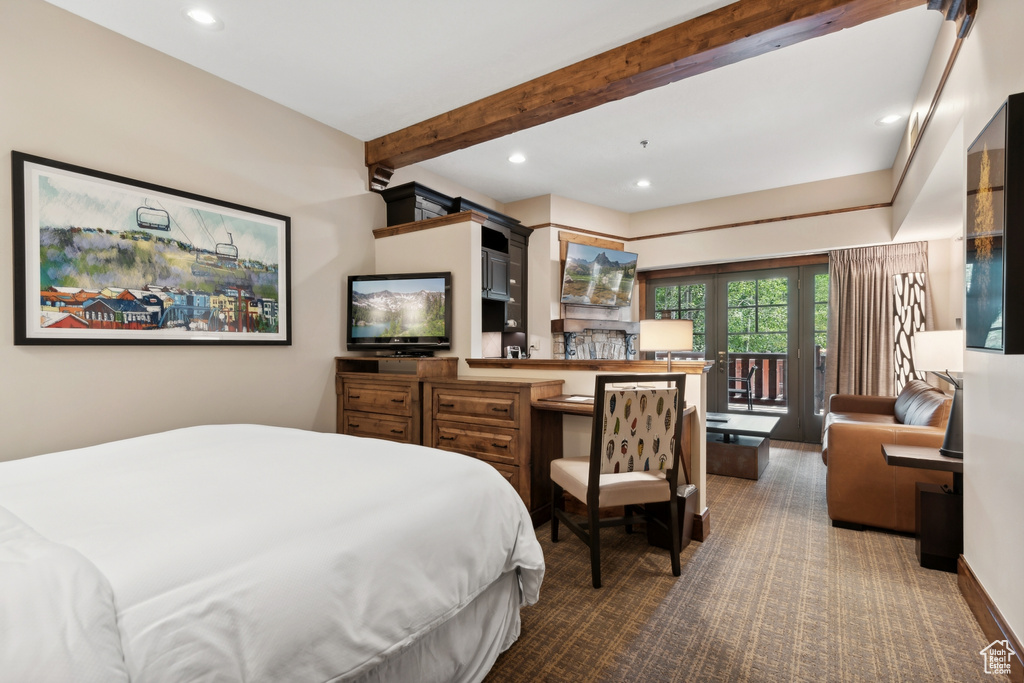 Bedroom featuring beamed ceiling and access to outside